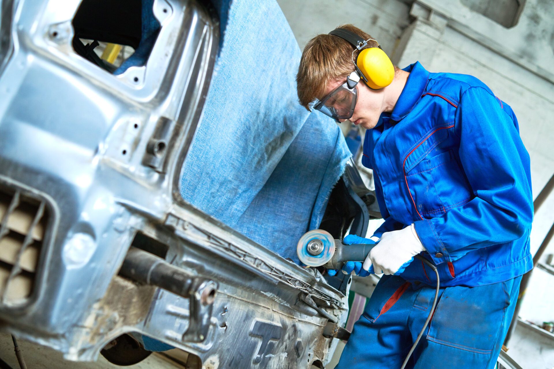 collision repairs service. mechanic grinding car body by grinder collision repairs service. auto repair mechanic cutting off or grinding car body by grinder